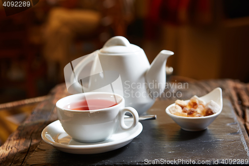 Image of white teapot with tea Cup, saucer and teaspoon