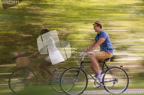 Image of Young multiethnic couple having a bike ride in nature