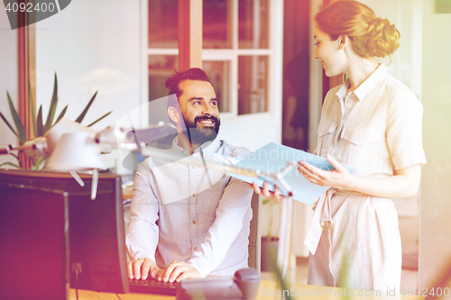 Image of business team with computer and files in office