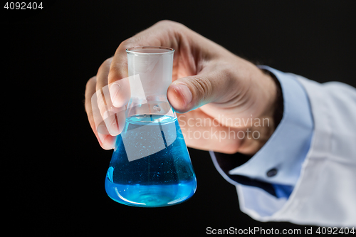 Image of close up of scientist holding flask with chemical