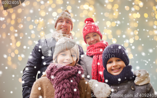 Image of happy family over christmas lights and snow