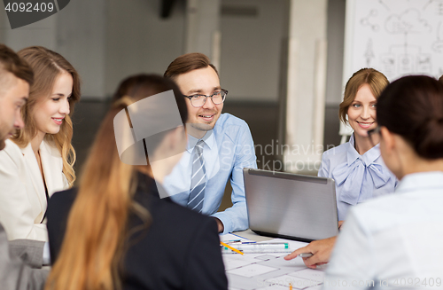 Image of architects with laptop and blueprint at office