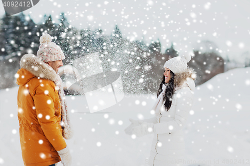 Image of happy couple playing with snow in winter