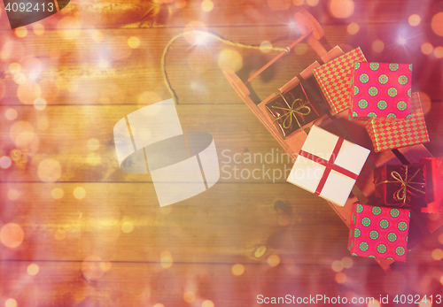 Image of close up of christmas gift boxes on wooden sleigh