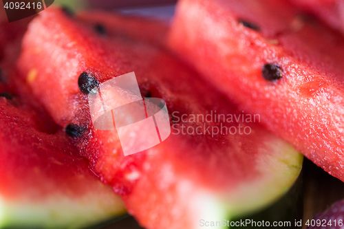 Image of close up of watermelon slices on wooden table