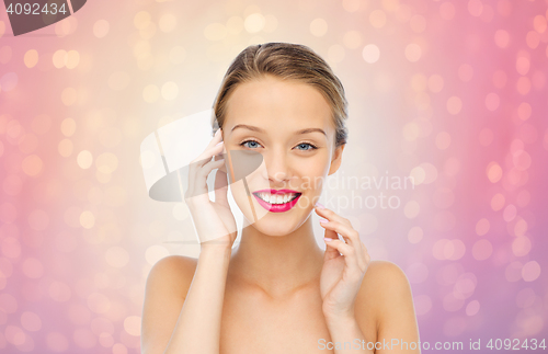 Image of smiling young woman with pink lipstick on lips