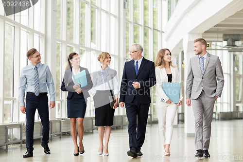 Image of business people walking along office building