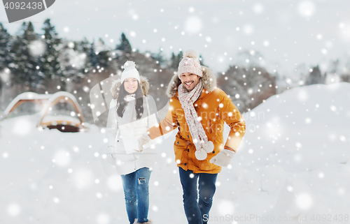 Image of happy couple running over winter background