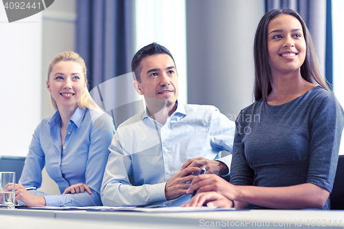 Image of group of smiling businesspeople meeting in office