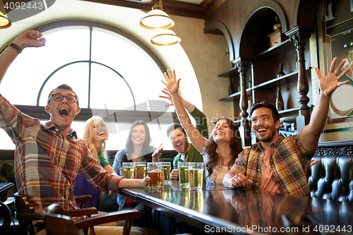 Image of friends with beer watching football at bar or pub