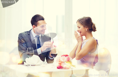 Image of man proposing to his girlfriend at restaurant