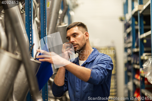 Image of auto mechanic with clipboard at car workshop
