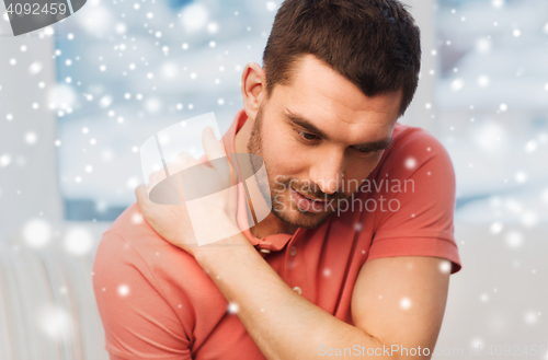 Image of unhappy man suffering from neck pain at home