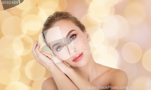 Image of beautiful woman face and hands over lights