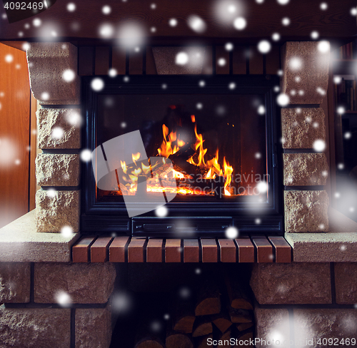 Image of close up of burning fireplace with snow