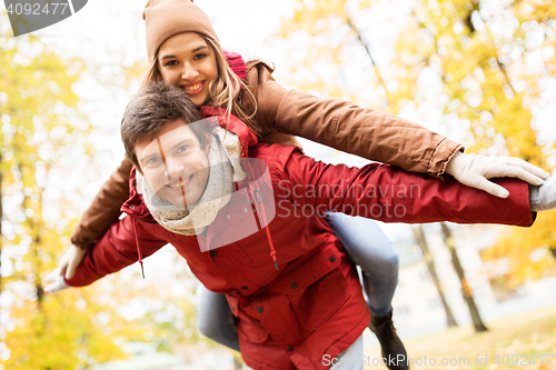 Image of happy young couple having fun in autumn park