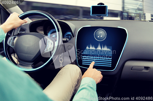 Image of close up of man driving car with audio system