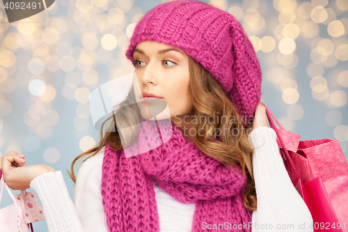 Image of happy woman in winter clothes with shopping bags