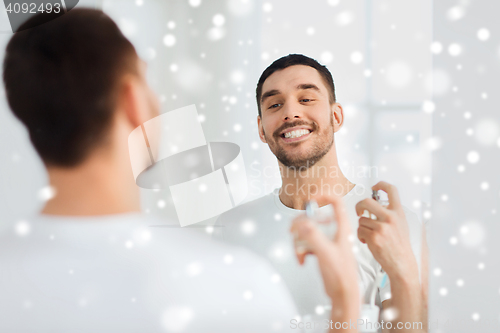 Image of man with perfume looking to mirror at bathroom