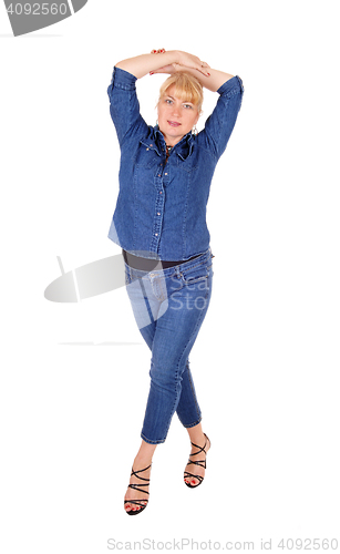 Image of Woman standing  with hands on head.