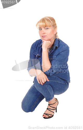 Image of Woman kneeling on floor. 