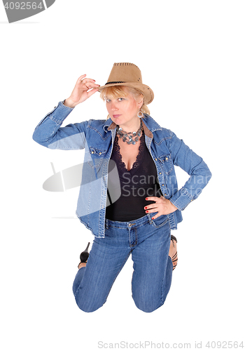 Image of Woman kneeling on floor with hat. 