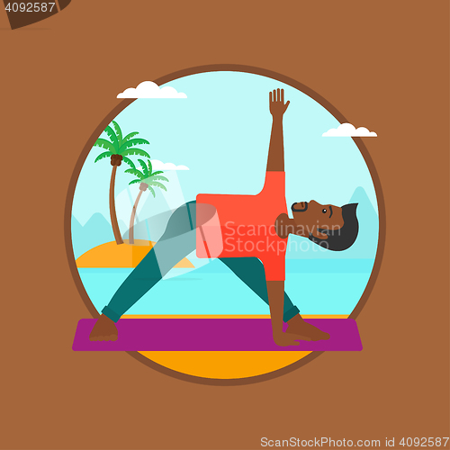 Image of Man practicing yoga triangle pose on the beach.