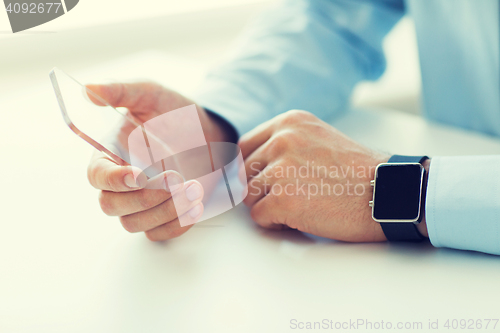 Image of close up of hands with smart phone and watch