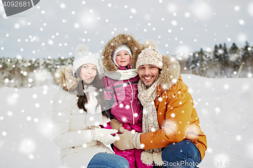 Image of happy family with child in winter clothes outdoors