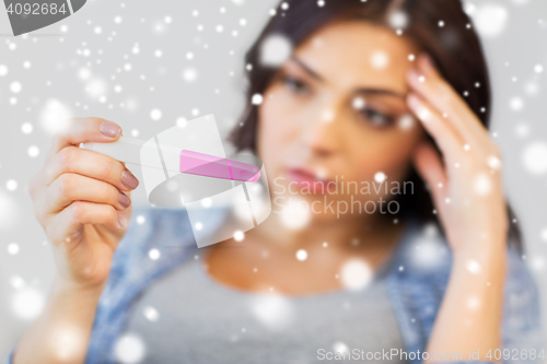 Image of close up of sad woman with home pregnancy test