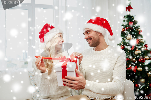 Image of happy couple at home with christmas gift box