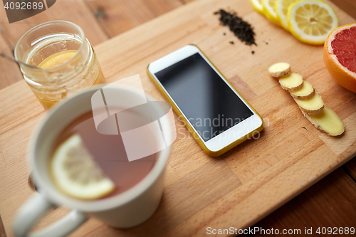 Image of smartphone with cup of lemon tea, honey and ginger