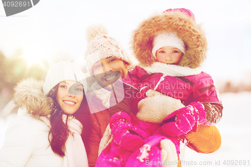 Image of happy family with child in winter clothes outdoors