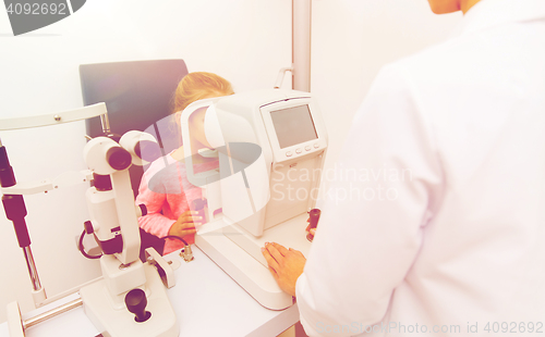 Image of optician with autorefractor and kid at eye clinic