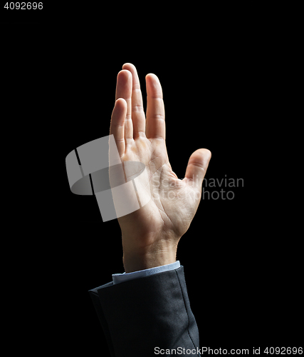 Image of close up of raised businessman hand over black