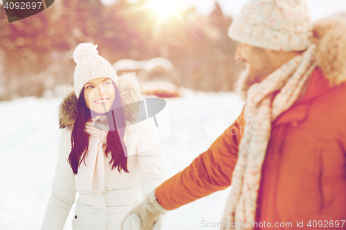 Image of happy couple walking along snowy winter field