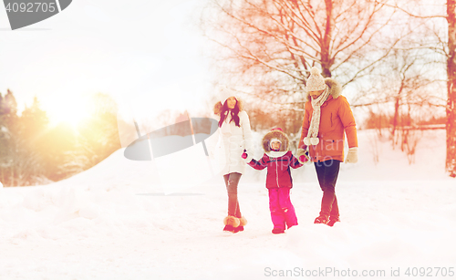 Image of happy family in winter clothes walking outdoors