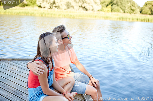 Image of happy teenage couple hugging on river berth