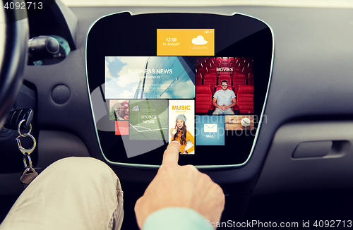 Image of close up of male hand media applications in car