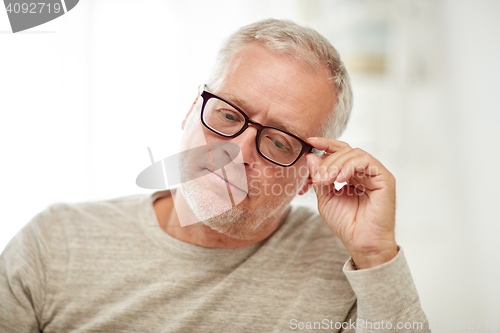 Image of close up of senior man in glasses thinking