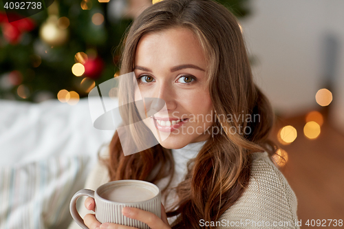 Image of happy woman drinking cocoa at home for christmas