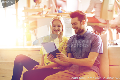 Image of happy creative team with tablet pc in office