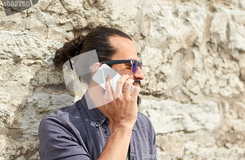 Image of close up of man calling on smartphone in city