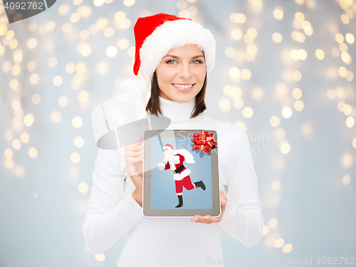 Image of woman holding tablet pc with santa claus on screen