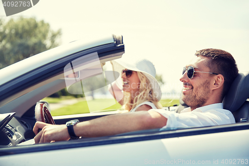 Image of happy man and woman driving in cabriolet car