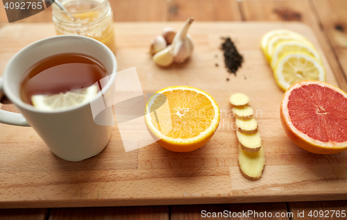 Image of ginger tea with honey, citrus and garlic on wood