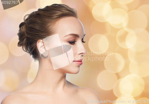 Image of beautiful young woman face over holidays lights