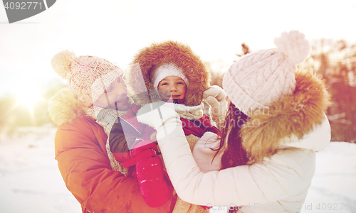 Image of happy family with child in winter clothes outdoors