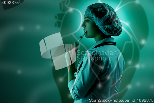 Image of Collage on scientific topics. Young female doctor standing against heart background