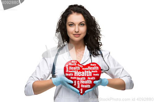 Image of Pretty woman doctor holding a red heart